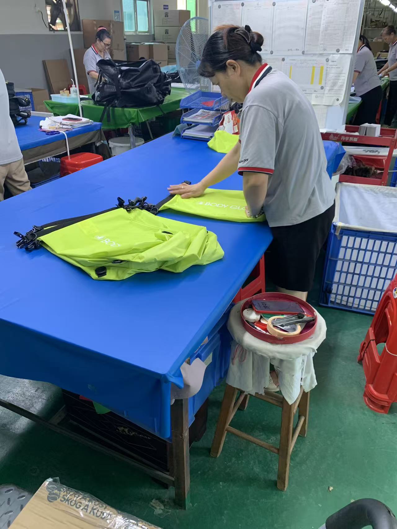 Come un ordine di borsa impermeabile roll-top ad alta visibilità viene cucito, controllato e imballato